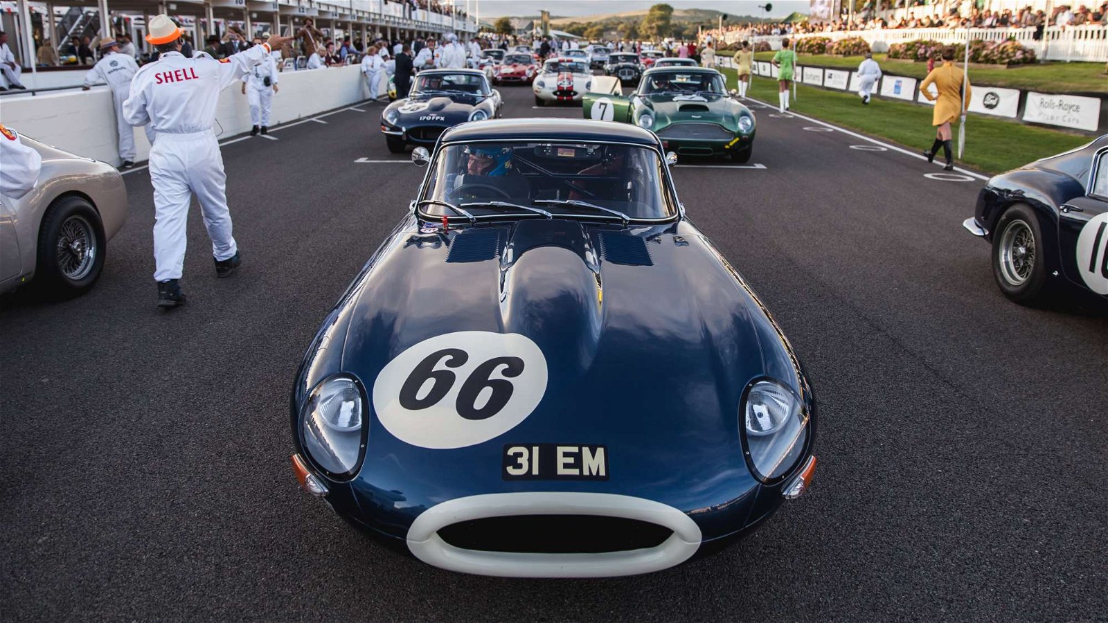 A Jaguar E-Type on the grid surrounded by more E-Types, Aston Martin DB4 GTs and Ferrari 250 GT SWBs. Taken by Tim Brown for Goodwood